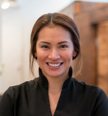 Portrait of a happy business owner at a spa with a group of workers looking at the camera smiling